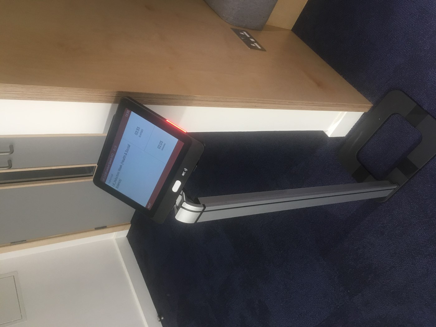 NFC attendance display on a floor stand beside a room entrance