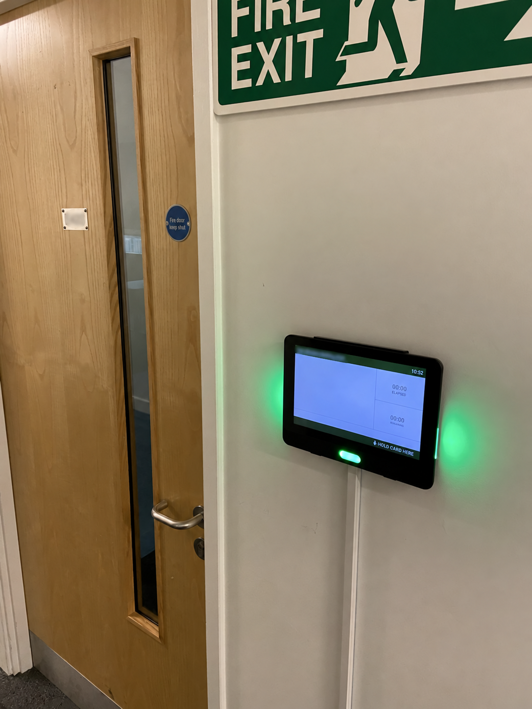 NFC attendance display mounted beside a teaching-room entrance, with green status LEDs